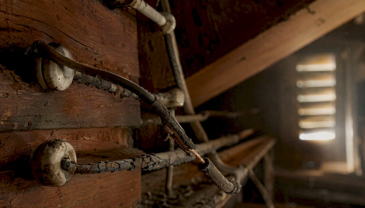 Deteriorated knob and tube wire insulation close-up