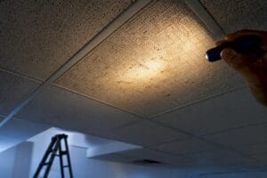 Inspector examining intact commercial ceiling tiles
