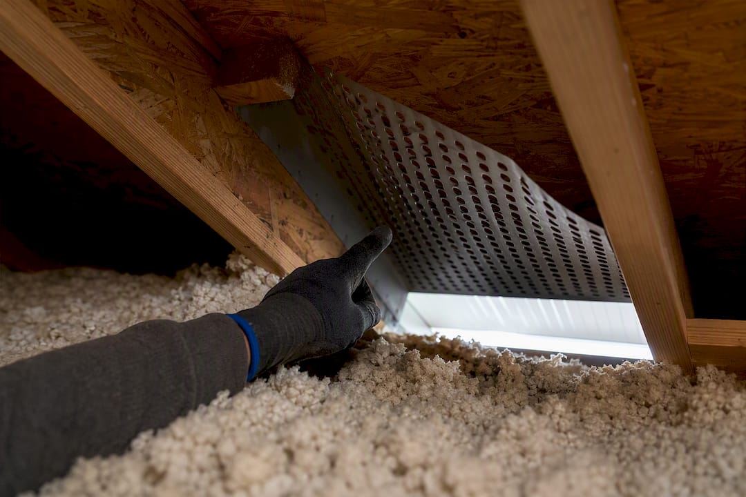 Soffit vent baffle above attic insulation