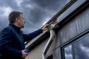 Inspector examining storm-damaged commercial gutter