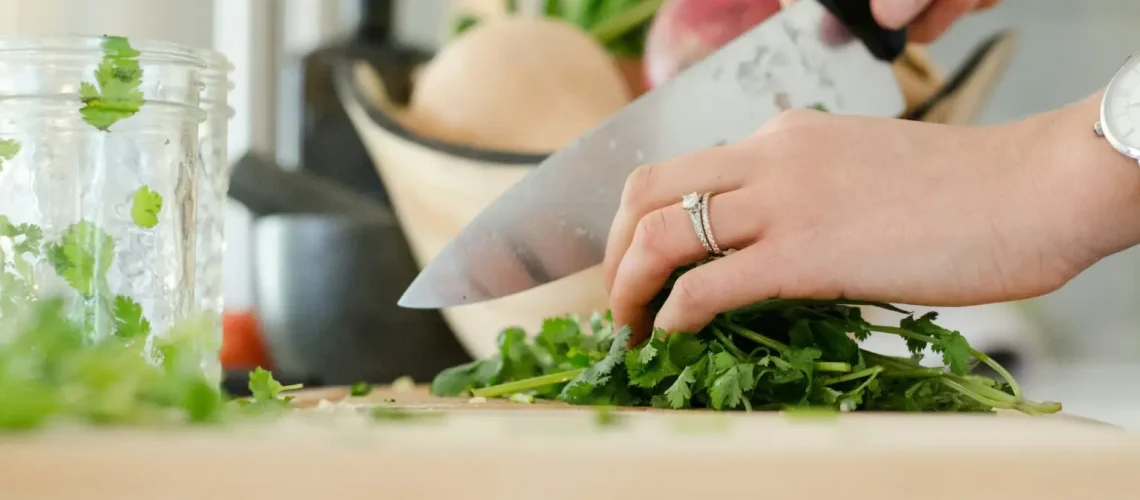 alyson-mcphee-yWG-ndhxvqY-unsplash-1536×1017 a person cutting parsley on a cutting board